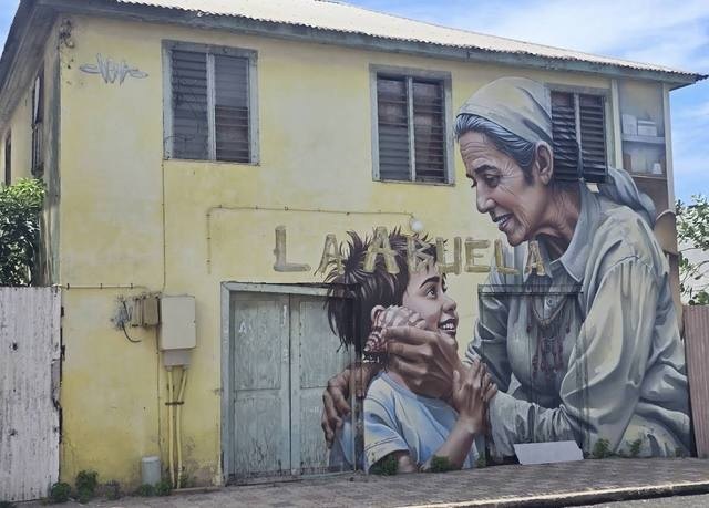 La Abuela mural on a yellow house in San Nicolas, Aruba