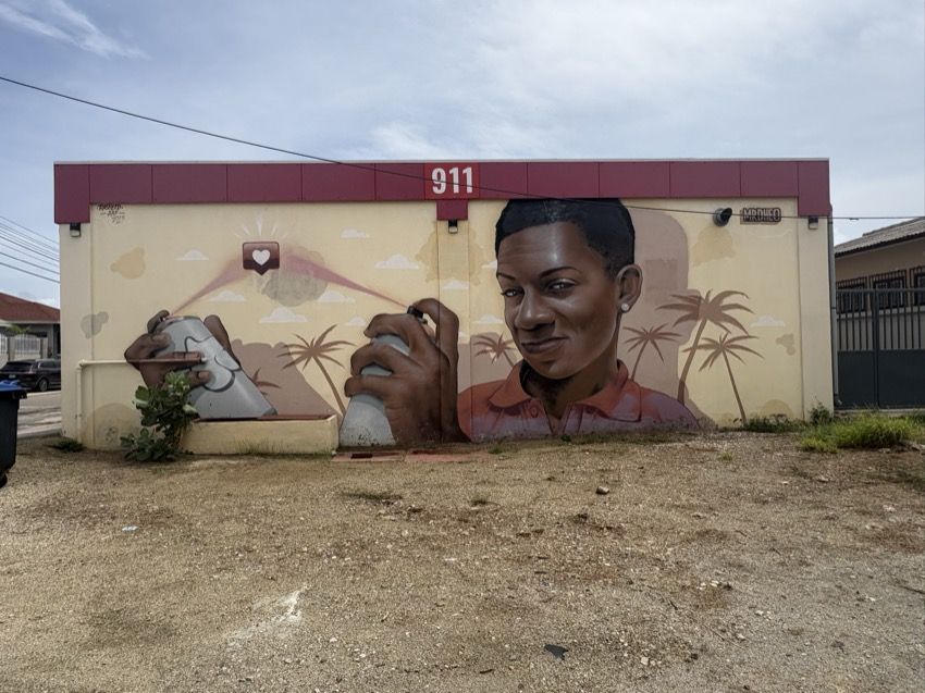 Mural of a young artist with spray cans under the number 911